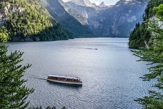 Blick auf den Königssee mit einem Schiff auf dem See und Berge im Hintergrund