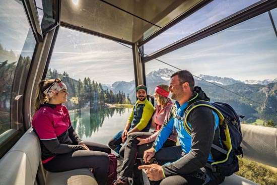 Group of hikers in the cable car above the lake with a view of the mountains