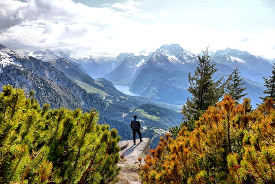 Herbststimmung am Berg, Person schaut auf den Königssee und die Berge Herbststimmung am Berg, Person schaut auf den Königssee und die Berge