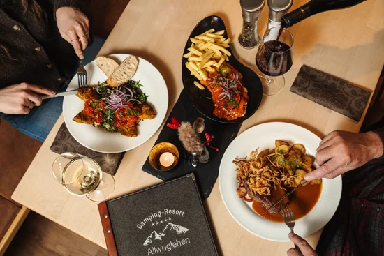 A view of a set table where people are currently eating.