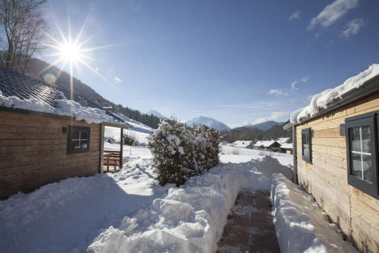 Außenansicht zwischen den Chalets bei winterlicher Umgebung mit Blick auf die Berge. Außenansicht zwischen den Chalets bei winterlicher Umgebung mit Blick auf die Berge.