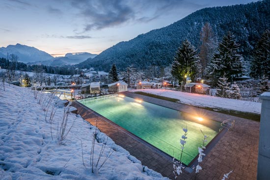 Beleuchteter Infinity Pool im Winter bei Abendstimmung