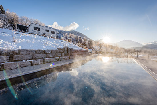 Infinity Pool an einem sonnigen Wintertag mit Wohnwagen rechts im Bild