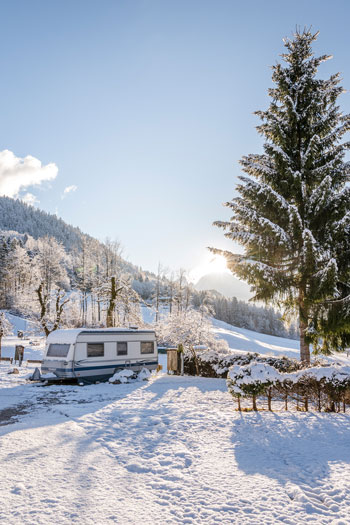 Ein Wohnwagen mit winterlicher Landschaft an einem sonnigen Tag. Ein Wohnwagen mit winterlicher Landschaft an einem sonnigen Tag.