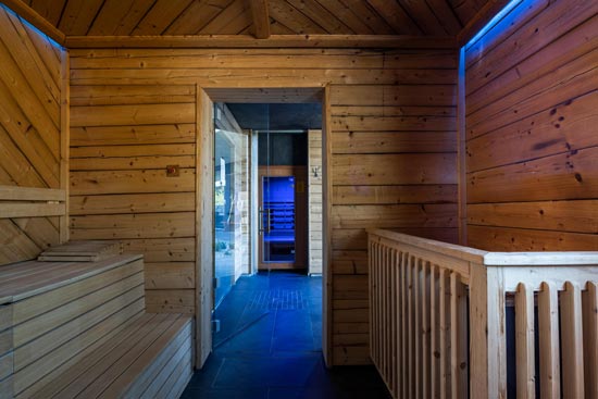 Innenansicht der Sauna mit stimmungsvoller Beleuchtung an den Seiten & der Türe.