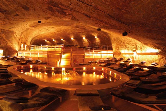 Innenansicht vom Heilstollen Berchtesgaden mit Blick auf den kleinen Salzsee, Liegen drumherum.