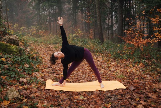 Yogalehrerin im Herbst, wie sie Wald eine Yogapose auf einer gelben Matte macht. Yogalehrerin im Herbst, wie sie Wald eine Yogapose auf einer gelben Matte macht.